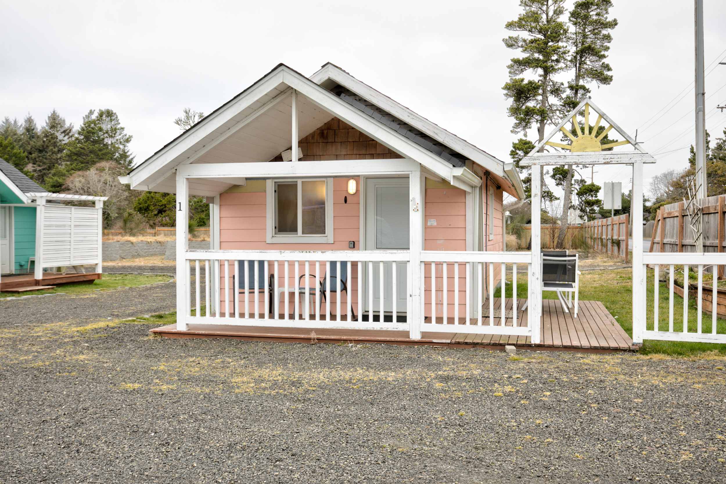 Cottage 1 exterior — pink cottage with covered porch and sun arch