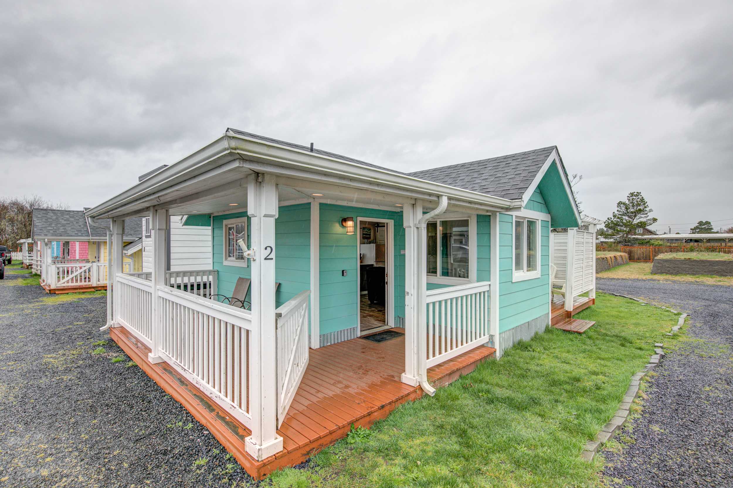 Cottage 2 exterior — teal with white trim and covered porch